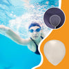 Person swimming underwater with a close-up of a swim cap and goggles on an orange and blue background.