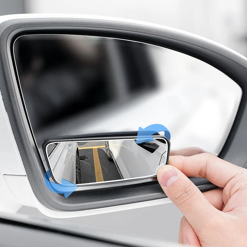 Person installing a car mirror cover with adhesive strips on a vehicle's side mirror.