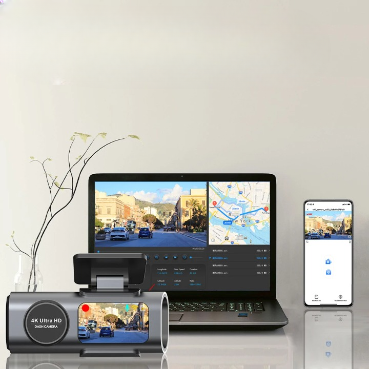 A 4K Ultra HD car dashcam shown in a studio setup alongside a laptop and smartphone displaying the connected video feed and map interface, on a light neutral background.