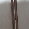 Close-up of a brown zipper track and mesh door panel on a light gray fabric closet door.